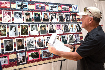 Former Marine Mark Morgan comparing the list of names on the clipboard to the pictures. undefined