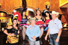 Toni McDole and Don Williams take a photo op with the Grand Hotel & Saloon dance hall girls.