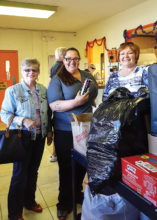 Marian Bianchini and Mary Schlachter deliver the donations to Liz, center, at PACC; photo by Deb Lawson