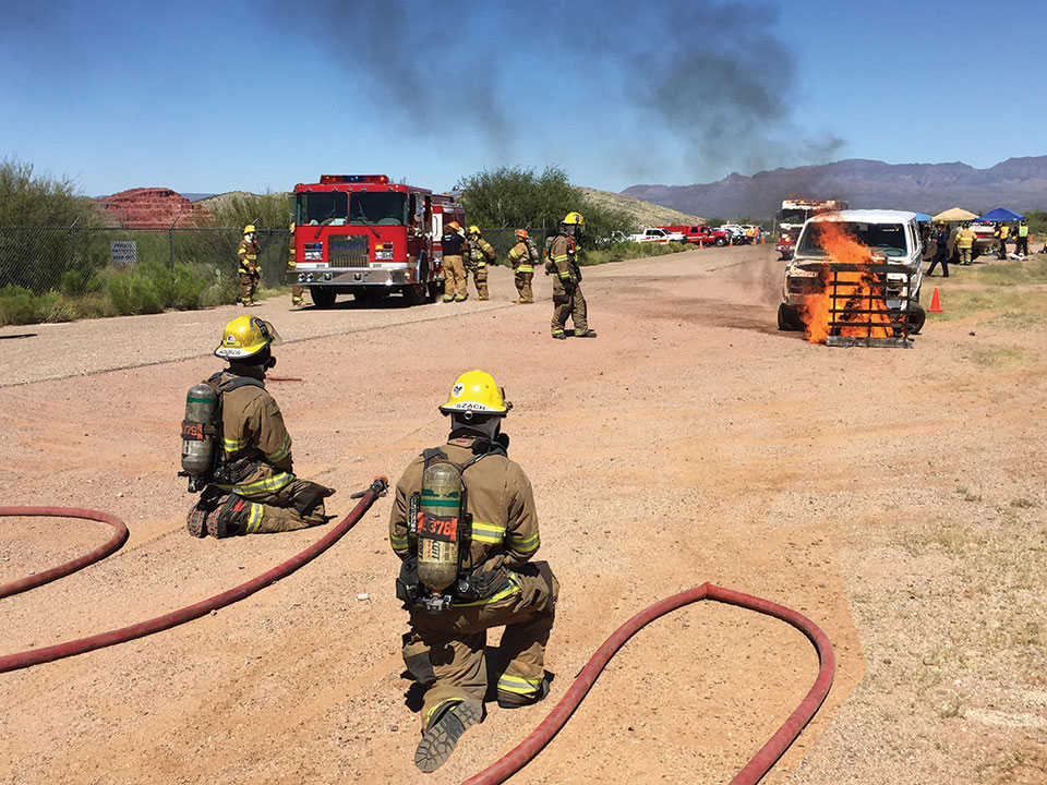 The fire fighters at a training session where they are learning the proper procedures to extinguish a vehicle blaze; Photo by Steve Weiss