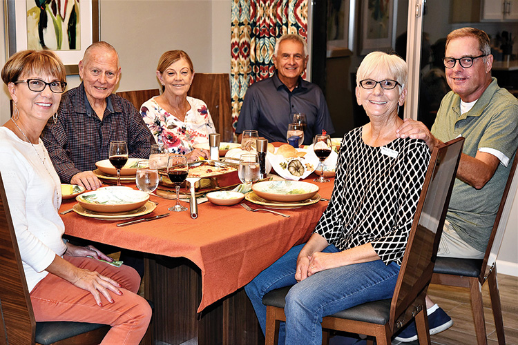 Clockwise, (left to right): Kathie Calbone, Dick Ryan, Betty Ryan, Sam Calbone, Mary Jo Stastny, and Lee Stastny enjoy a lasagna main course at the Calbone home during the Unit 8A progressive dinner.