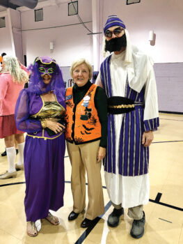 Ranchero Rebecca Williams in Halloween vest flanked by Ted and Ruthie Thoren dressed as a sultan and his lady.