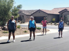 D. Fitzgerald, Doris Carlin, Corky Mansmith, and Linda Newton practice social distancing on a walk.