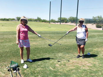 Lisa Brown and Leslie Brown measure proper social distancing before golf.