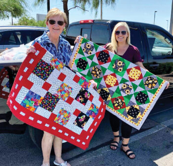 CJ Kerley from the SaddleBrooke Ranch Piecemakers (left) presenting quilts and household items to Meagan MacCleary with La Casa De Paz.
